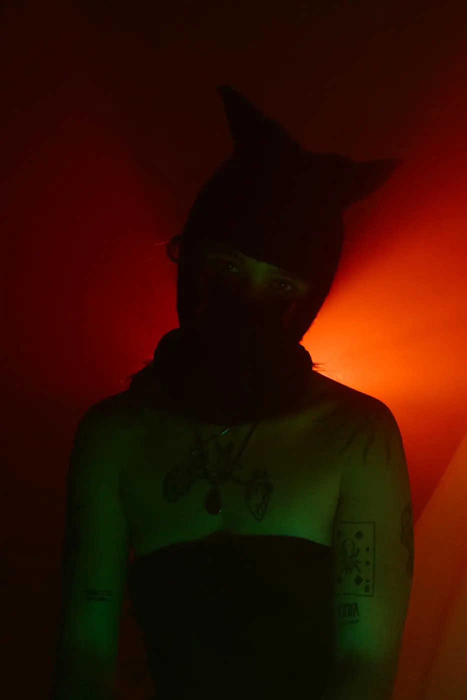 Torse et épaule tatoués sous une lumière rouge